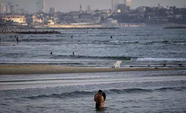 People bathe in the Mediterranean Sea along the beachfront in Tel Aviv, Israel, on Saturday, June 14, 2025. (AP Photo/Ohad Zwigenberg)