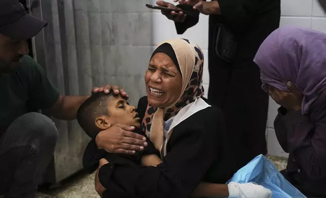 Sherine Abu Mor, embraces the body of her son, Hamza Al-Shaer, who was killed in an Israeli army airstrike, at the Al-Aqsa Hospital in Deir al-Balah, Gaza Strip, Saturday, June 14, 2025. (AP Photo/Abdel Kareem Hana)