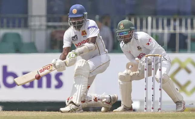 Sri Lanka's Prabath Jayasuriya plays a shot Bangladesh's Litton Das watches during the third day of the second cricket test match between Sri Lanka and Bangladesh in Colombo, Sri Lanka, Friday, June 27, 2025. (AP Photo/Eranga Jayawardena)