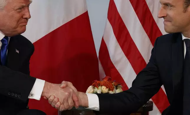 FILE - President Donald Trump shakes hands with French President Emmanuel Macron during a meeting at the U.S. Embassy, May 25, 2017, in Brussels. (AP Photo/Evan Vucci, File)