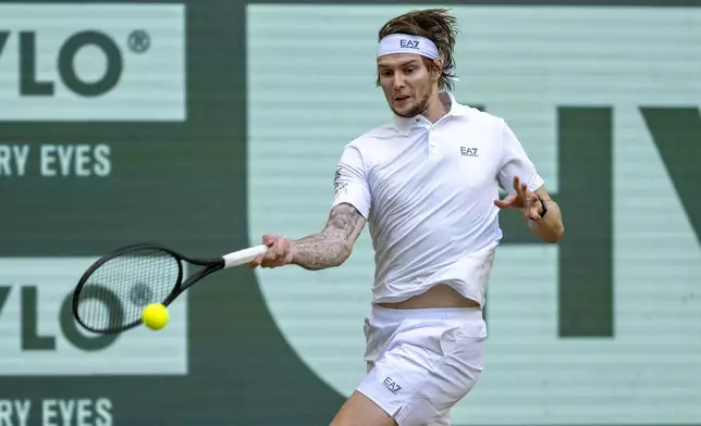 Kazakhstan's Alexander Bublik returns the ball to Russia's Karen Khachanov during their men's singles semifinal, at the Halle tennis tournament, Germany, Saturday, June 21, 2025. (David Inderlied/dpa via AP)