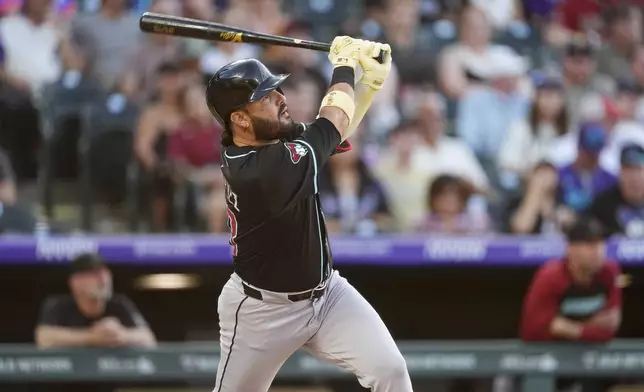 Arizona Diamondbacks' Eugenio Suárez follows the flight of his solo home run off Colorado Rockies starting pitcher Carson Palmquist in the third inning of a baseball game Saturday, June 21, 2025, in Denver. (AP Photo/David Zalubowski)