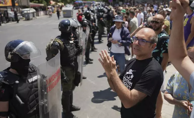 Serbian gendarmerie officers stand in front of anti-government protesters in Belgrade, Serbia, Monday, June 30, 2025. (AP Photo/Darko Vojinovic)