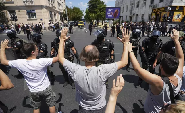 Serbian gendarmerie officers remove a street blockade that was set up as part of a protest over a spate of arrests of anti-government protesters after a massive rally demanding an early parliamentary election in Belgrade, Serbia, Monday, June 30, 2025. (AP Photo/Darko Vojinovic)