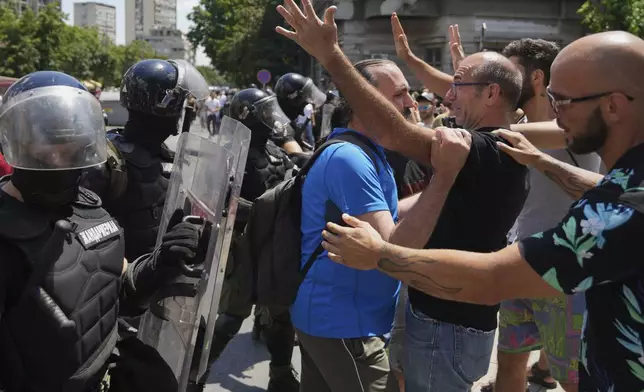 People react as Serbian gendarmerie officers remove a street blockade that was set up as part of a protest over a spate of arrests of anti-government protesters after a massive rally demanding an early parliamentary election in Belgrade, Serbia, Monday, June 30, 2025. (AP Photo/Darko Vojinovic)