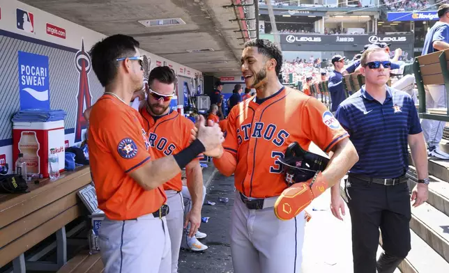 Houston Astros' Jeremy Peña, right, celebrates with Mauricio Dubón after scoring during the sixth inning of a baseball game against the Los Angeles Angels, Sunday, June 22, 2025, in Anaheim, Calif. (AP Photo/William Liang)
