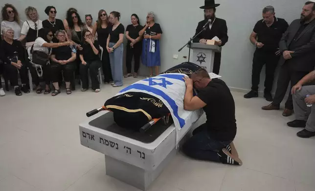 Nikolay Boguslavsky mourns over the body of his daughter, Noa Boguslavsky, 18, who was killed in an Iranian missile strike on a residential building yesterday, a day after the announcement of a ceasefire between Israel and Iran, during her funeral at the cemetery in Arad, Israel, Wednesday, June 25, 2025. (AP Photo/Ariel Schalit)