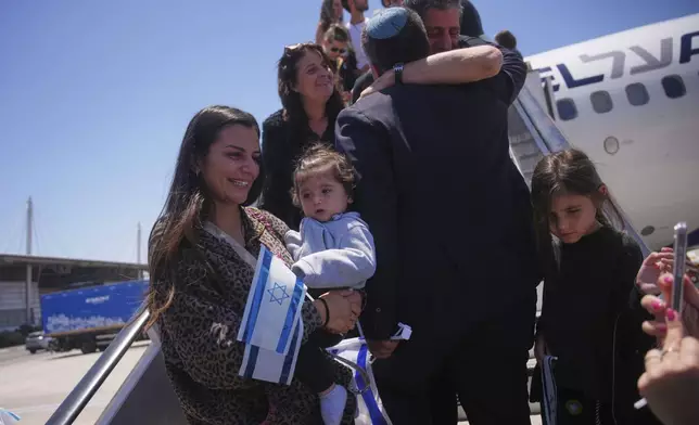 New Jewish immigrants from Spain, England, France and the Netherlands disembark from an airplane a day after the announcement of a ceasefire between Israel and Iran, as they arrive at Ben Gurion International Airport, near Tel Aviv, Wednesday, June 25, 2025. (AP Photo/Ohad Zwigenberg)