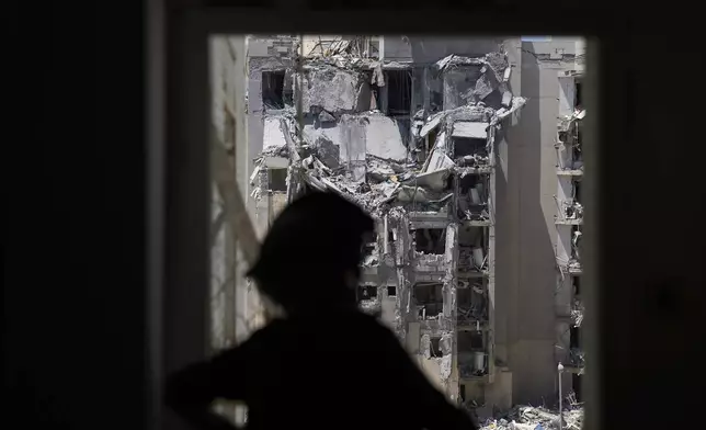 A police officer inspects a damaged apartment a day after a direct missile strike from Iran hit a residential building, killing several people, following the announcement of a ceasefire, in Beersheba, Israel, Wednesday, June 25, 2025. (AP Photo/Ariel Schalit)