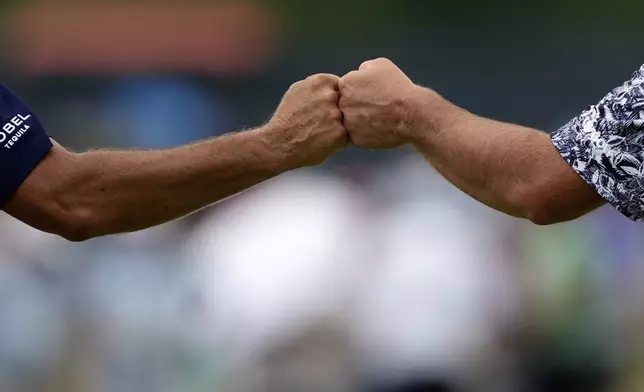 Jon Rahm, of Spain, gets a fist bump from his caddie, Adam Hayes, left, after sinking a putt for birdie on the eighth hole during the third round of the U.S. Open golf tournament at Oakmont Country Club Saturday, June 14, 2025, in Oakmont, Pa. (AP Photo/Carolyn Kaster)
