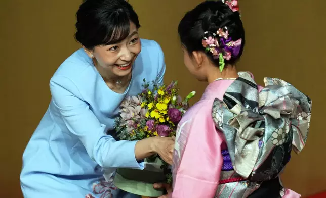 Japan's Princess Kako of Akishino receives a bouquet of flowers from a girl during a meeting at the Bunkyo Brazilian Society of Japanese Culture in Sao Paulo, Friday, June 6, 2025. (AP Photo/Andre Penner)
