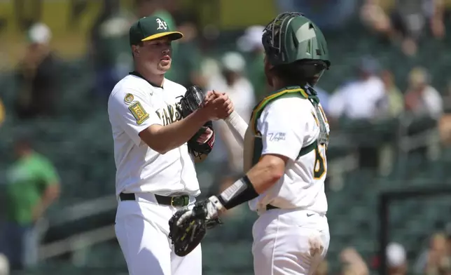 Athletics pitcher Mason Miller, left, and catcher Willie MacIver, right, celebrate their victory over the Minnesota Twins following a baseball game, Thursday, June 5, 2025, in West Sacramento, Calif. (AP Photo/Scott Marshall)