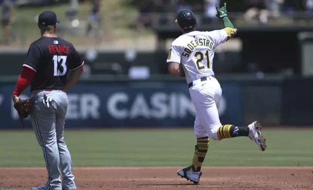 Athletics' Tyler Soderstrom (21) gestures towards the bullpen after hitting a two-run home run against the Minnesota Twins during the third inning of a baseball game Thursday, June 5, 2025, in West Sacramento, Calif. (AP Photo/Scott Marshall)
