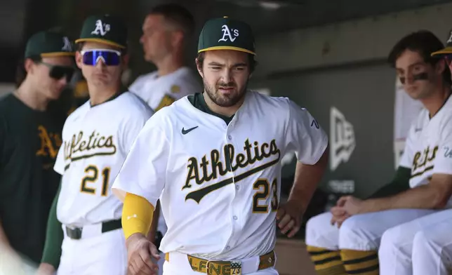 Athletics' Shea Langeliers (23) grabs at his side after being removed from the game after taking a swing against the Minnesota Twins during the sixth inning of a baseball game Thursday, June 5, 2025, in West Sacramento, Calif. (AP Photo/Scott Marshall)