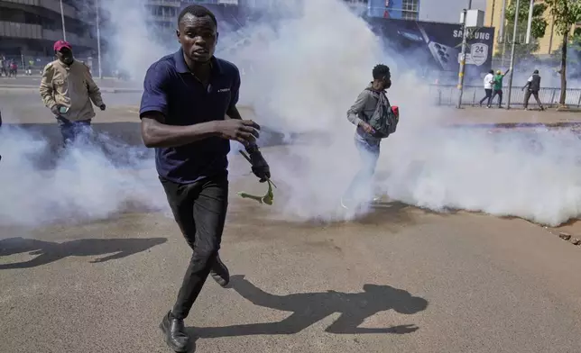 Protesters scatter as police fire teargas at them during a demonstration in downtown Nairobi, Kenya, Wednesday, June 25, 2025. (AP Photo/Brian Inganga)