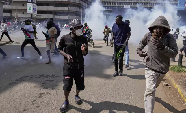 Protesters scatter as police fire teargas at them during a demonstration in downtown Nairobi, Kenya, Wednesday, June 25, 2025. (AP Photo/Brian Inganga)