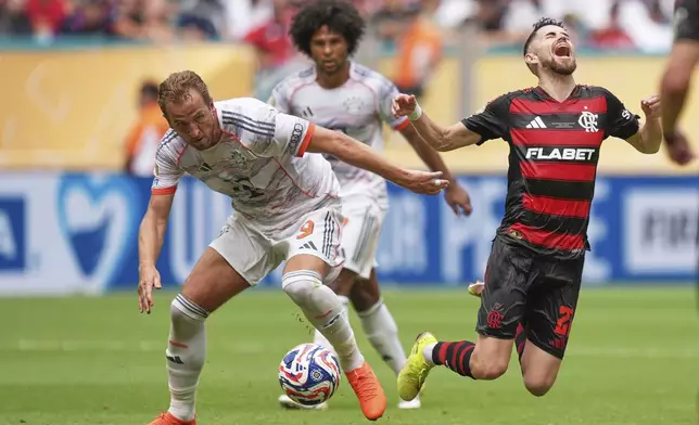 Flamengo's Jorginho, right, falls chased by Bayern Munich's Harry Kane during the Club World Cup round of 16 soccer match between CR Flamengo and Bayern Munich in Miami Gardens, Fla., Sunday, June 29, 2025. (AP Photo/Rebecca Blackwell)