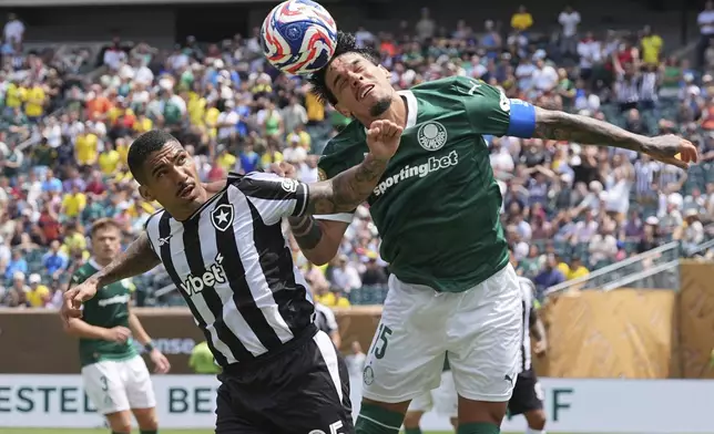 Palmeiras' Gustavo Gomez (15) heads the ball over Botafogo's Allan (25) during the Club World Cup round of 16 soccer match between Palmeiras and Botafogo in Philadelphia, Saturday, June 28, 2025. (AP Photo/Matt Rourke)