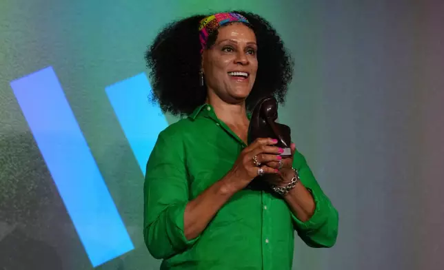 Women's prize outstanding contribution award winner Bernardine Evaristo, poses with her trophy, at the prize giving event, in London, Thursday, June 12, 2025. (AP Photo/Joanna Chan)