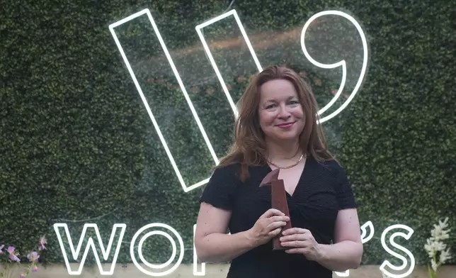 Winner of the Women's Prize for Fiction Rachel Clarke for her book 'The Story of a Heart' holds her trophy as she poses for the media in London, Thursday, June 12, 2025. (AP Photo/Joanna Chan)