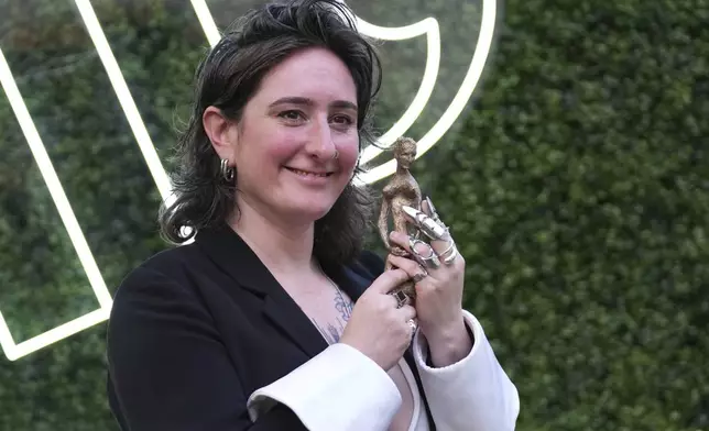 Winner of the Women's Prize for Non Fiction Yael van Der Wouden, who wrote 'The Safekeep' holds her trophy as she poses for the media in London, Thursday, June 12, 2025. (AP Photo/Joanna Chan)