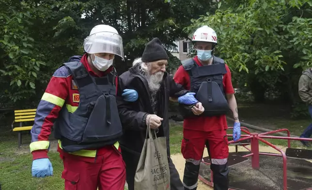 An elderly man is assisted after a Russian attack that hit a residential building in Kharkiv, Ukraine, Saturday, June 7, 2025. (AP Photo/Andrii Marienko)