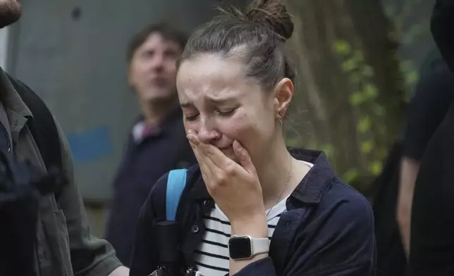 A woman reacts as she looks on a multi-storey building damaged by a Russian strike in Kharkiv, Ukraine, Saturday, June 7, 2025. (AP Photo/Andrii Marienko)