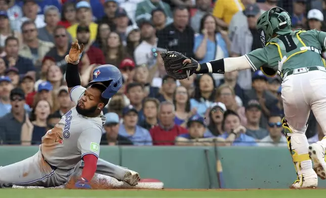 Boston Red Sox catcher Connor Wong, right, misses a tag on Toronto Blue Jays' Vladimir Guerrero Jr., left, who slides safely into home plate in the first inning of a baseball game Friday, June 27, 2025, in Boston. (AP/Photo/Jim Davis)