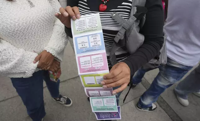 A supporter of Lenia Batres, who is running for election for the Mexican Supreme Court, holds an instruction sheet on how to vote, during her closing campaign rally in Mexico City, Wednesday, May 28, 2025. (AP Photo/Fernando Llano)