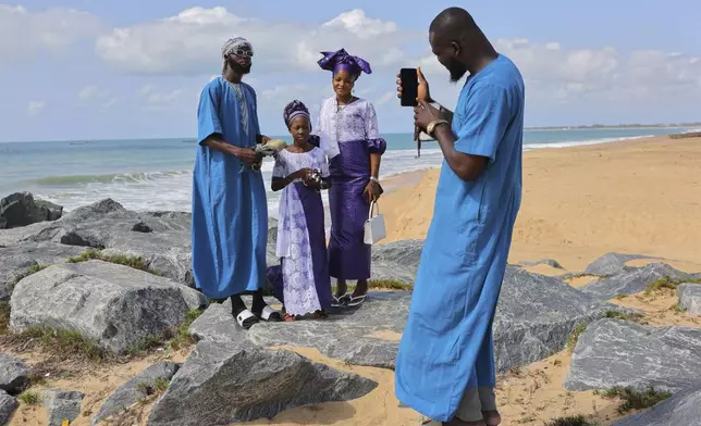 A family poses for photograph at a beach after Eid al-Adha prayers in Keta, Ghana, Friday, Jun 6, 2025 (AP Photo/Misper Apawu)