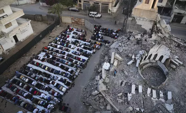 Palestinians offer Eid al-Adha prayers beside the ruins of a mosque destroyed by Israeli bombardment, in Deir al-Balah, Gaza on Friday, June 6, 2025. (AP Photo/Abdel Kareem Hana)