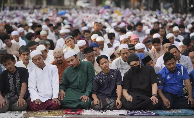 Muslims perform Eid al-Adha prayer on a street in Jakarta, Indonesia, Friday, June 6, 2025. (AP Photo/Dita Alangkara)