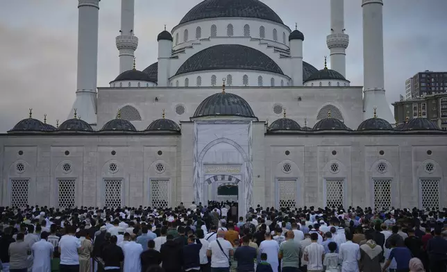 Muslims attend the prayer of the first day of Eid al-Adha, outside a mosque in Istanbul, Friday, June 6, 2025. (AP Photo/Khalil Hamra)