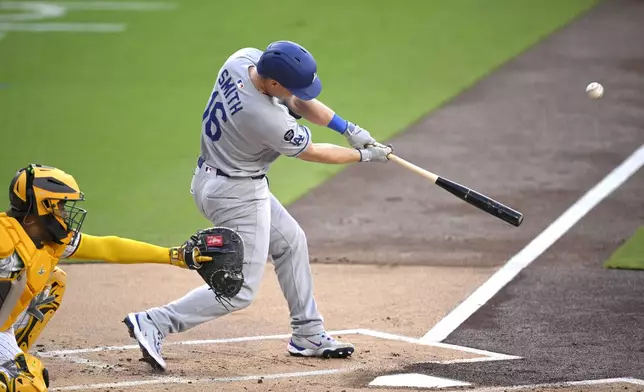 Los Angeles Dodgers' Will Smith (16) hits a sacrifice fly against the San Diego Padres during the first inning of a baseball game Monday, June 9, 2025, in San Diego. (AP Photo/Orlando Ramirez)