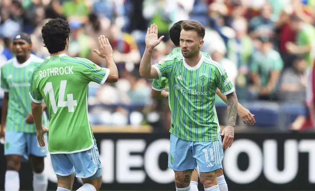Seattle Sounders' Albert Rusnak, right, is congratulated after scoring his side's first goal during the Club World Cup group B soccer match between Seattle Sounders and Atletico Madrid in Seattle, Thursday, June 19, 2025. (AP Photo/Lindsey Wasson)