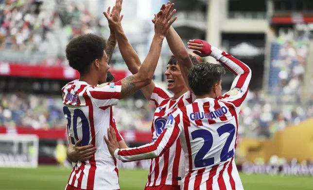 Atletico Madrid's Axel Witsel, left, is congratulated by teammates Robin Le Normand and Giuliano Simeone, right, after scoring his team's second goal during the Club World Cup group B soccer match between Seattle Sounders and Atletico Madrid in Seattle, Thursday, June 19, 2025. (AP Photo/Ryan Sun)