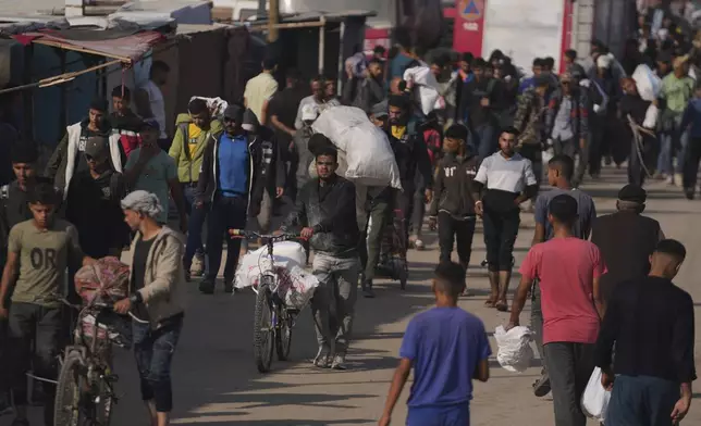 Palestinians carry bags containing food and humanitarian aid packages delivered by the Gaza Humanitarian Foundation, a U.S.-backed organization approved by Israel in Khan Younis, southern Gaza Strip, Sunday, June 1, 2025. (AP Photo/Abdel Kareem Hana)