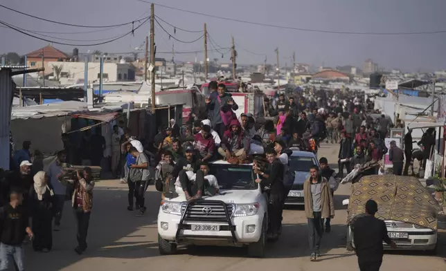 Moving on a vehicle, Palestinians transport humanitarian aid bags delivered by the Gaza Humanitarian Foundation, a U.S.-backed organization approved by Israel, in Khan Younis, southern Gaza Strip, Sunday, June 1, 2025. (AP Photo/Abdel Kareem Hana)
