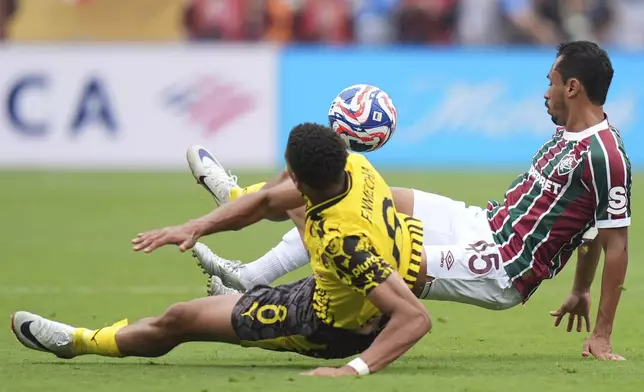 Fluminense's Lima, right, and Borussia Dortmund's Felix Nmecha fall while battling for the ball during the Club World Cup group F soccer match between Fluminense and Borussia Dortmund in East Rutherford, N.J., Tuesday, June 17, 2025. (AP Photo/Frank Franklin II)
