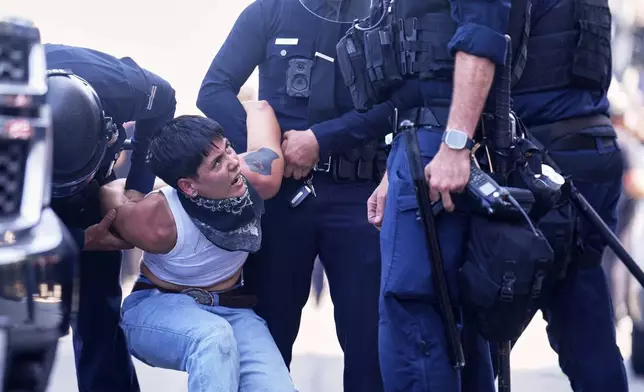 FILE - A protester is detained in downtown Los Angeles, Sunday, June 8, 2025, following last night's immigration raid protest. (AP Photo/Eric Thayer, File)