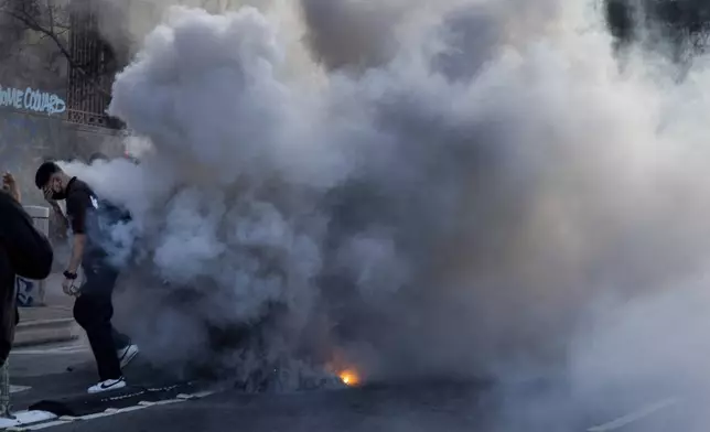 FILE - A person reacts to irritants during protests near the Metropolitan Detention Center in downtown Los Angeles, Sunday, June 8, 2025. (AP Photo/Ethan Swope, File)