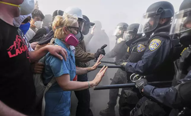 FILE - Protesters confront police on the 101 Freeway near the Metropolitan Detention Center in downtown Los Angeles, Sunday, June 8, 2025, following last night's immigration raid protest. (AP Photo/Jae C. Hong, File)