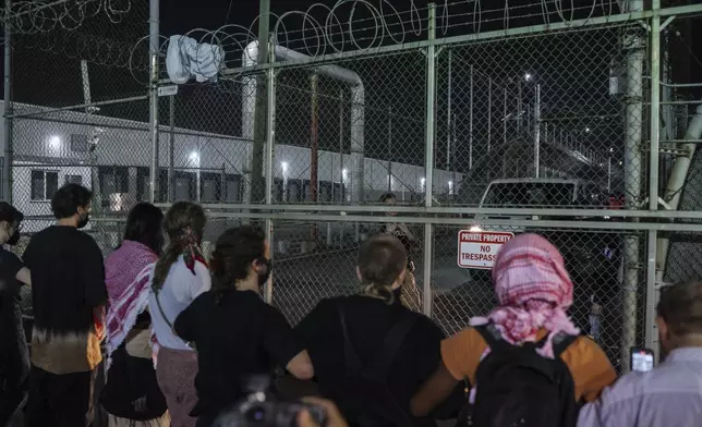 Protesters link hands at the gates of the Delaney Hall Detention Facility to prevent vehicles from exiting during protests over federal immigration enforcement raids on Thursday, June 12, 2025, in Newark, N.J. (AP Photo/Olga Fedorova)