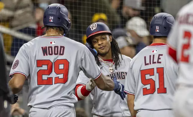 Washington Nationals' James Wood (29) celebrates his RBI home run with Luis García Jr., center, and Daylen Lile (51), in the eighth inning of a baseball game against the San Diego Padres, Monday, June 23, 2025, in San Diego. (AP Photo/Tony Ding)