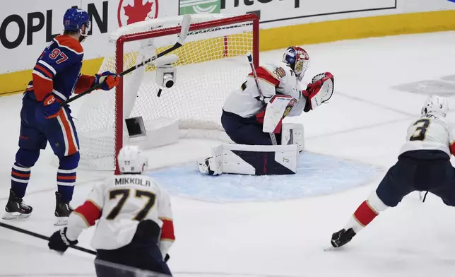 Edmonton Oilers' Leon Draisaitl (not shown) scores on Florida Panthers goalie Sergei Bobrovsky (72) as Oilers' Connor McDavid (97) looks on and Panthers' Seth Jones (3) defends during the first overtime period in Game 1 of the NHL Stanley Cup Final, in Edmonton, Alberta, on Wednesday, June 4, 2025. (Darryl Dyck/The Canadian Press via AP)