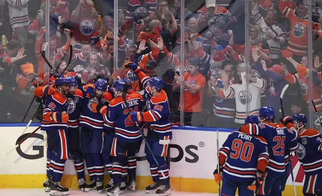 Edmonton Oilers' Leon Draisaitl (second left) celebrates his game-winning goal against the Florida Panthers with teammates in the first overtime period in Game 1 of the NHL Stanley Cup Final, in Edmonton, Alberta, on Wednesday, June 4, 2025. (Darryl Dyck/The Canadian Press via AP)