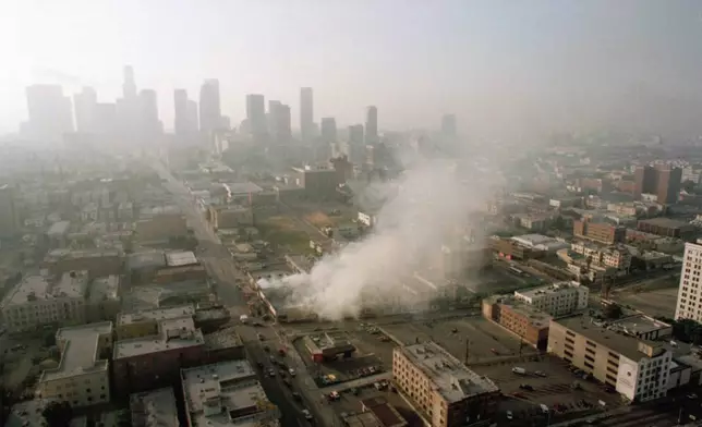 FILE - In this April 30, 1992 file photo, smoke rises from a shopping center burned by rioters in Los Angeles after four police officers had been acquitted of the 1991 beating of motorist Rodney King. (AP Photo/Paul Sakuma, File)