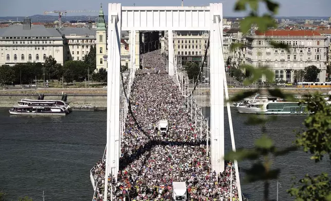 Participants in the Pride march cross the Elisabeth Bridge in Budapest, Hungary, Saturday, June 28, 2025. (AP Photo/Rudolf Karancsi)