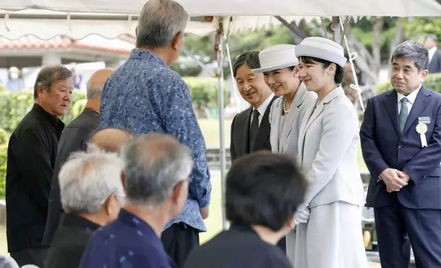 Japan's Emperor Naruhito, fourth right, Empress Masako, third right, and their daughter Princess Aiko, second right, meet the bereaved and others after laying flowers before an ossuary at the National War Dead Peace Mausoleum in Itoman, Okinawa prefecture Wednesday, June 4, 2025. (Takumi Sato/Kyodo News via AP)