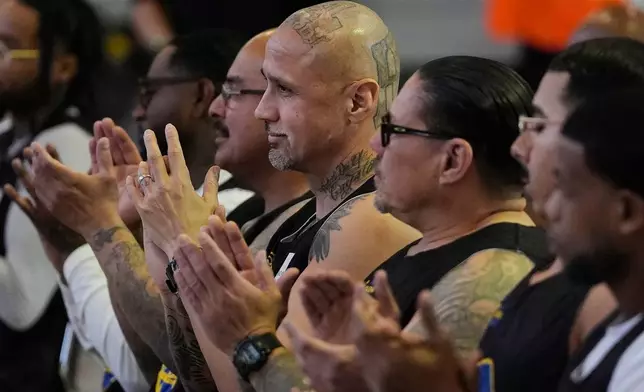 Michael San Agustin, middle, and other Twinning Project cohort 2 participants applaud speakers during the project's collaboration with the NBA's Golden State Warriors and the California Department of Corrections and Rehabilitation at Solano State Prison in Vacaville, Calif., Tuesday, Feb. 11, 2025. (AP Photo/Jeff Chiu)